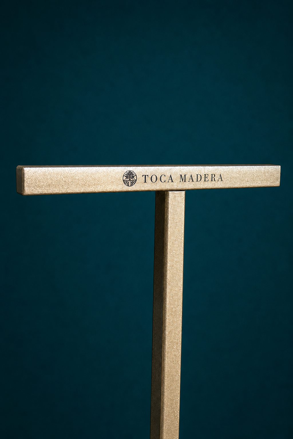 A Luxestands top bar in textured champagne bronze against deep teal, carrying an engraved property crest and wordmark.